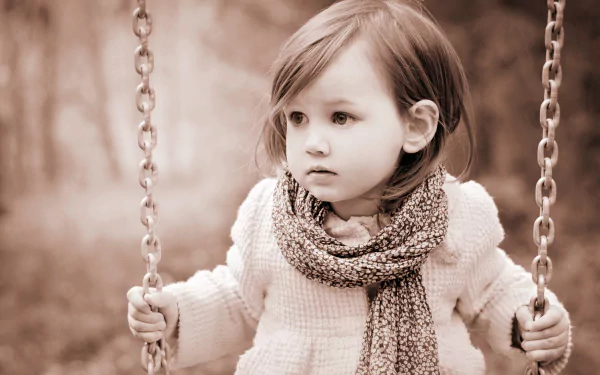 Sepia-toned 4K Ultra HD desktop wallpaper capturing a cute little girl on a swing, showcasing charming child photography in soft, nostalgic tones.