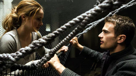 A scene from the movie Divergent featuring two characters engaged in an intense conversation behind a web of ropes, captured in a high-definition desktop wallpaper.