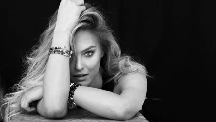 Black and white HD desktop wallpaper featuring Israeli celebrity model Bar Refaeli posing with her arm resting on a surface against a dark background.