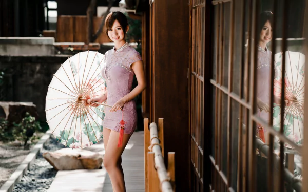 An Asian brunette woman smiles and poses with a parasol outside a wooden building in a high-definition desktop wallpaper background.