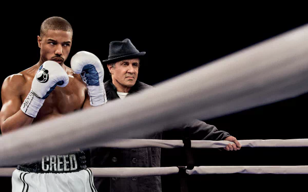 HD PC desktop wallpaper featuring Adonis Creed (Michael B. Jordan) and Rocky Balboa (Sylvester Stallone) from the movie Creed in a boxing ring.