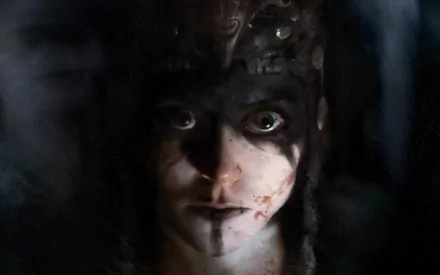 Close-up of Senua (Hellblade) — blood-streaked, war-painted face emerging from shadow; 4K Ultra HD PC desktop wallpaper/background from Hellblade: Senua's Sacrifice