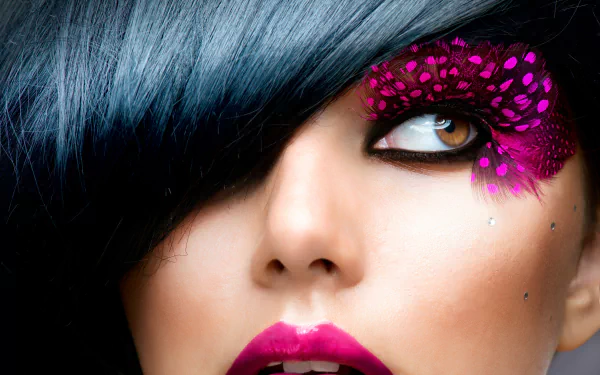 Close-up of a woman’s face with brown eyes, bold purple lipstick, dramatic eyelashes, and vibrant purple feather makeup, captured in 4K Ultra HD for PC wallpaper.