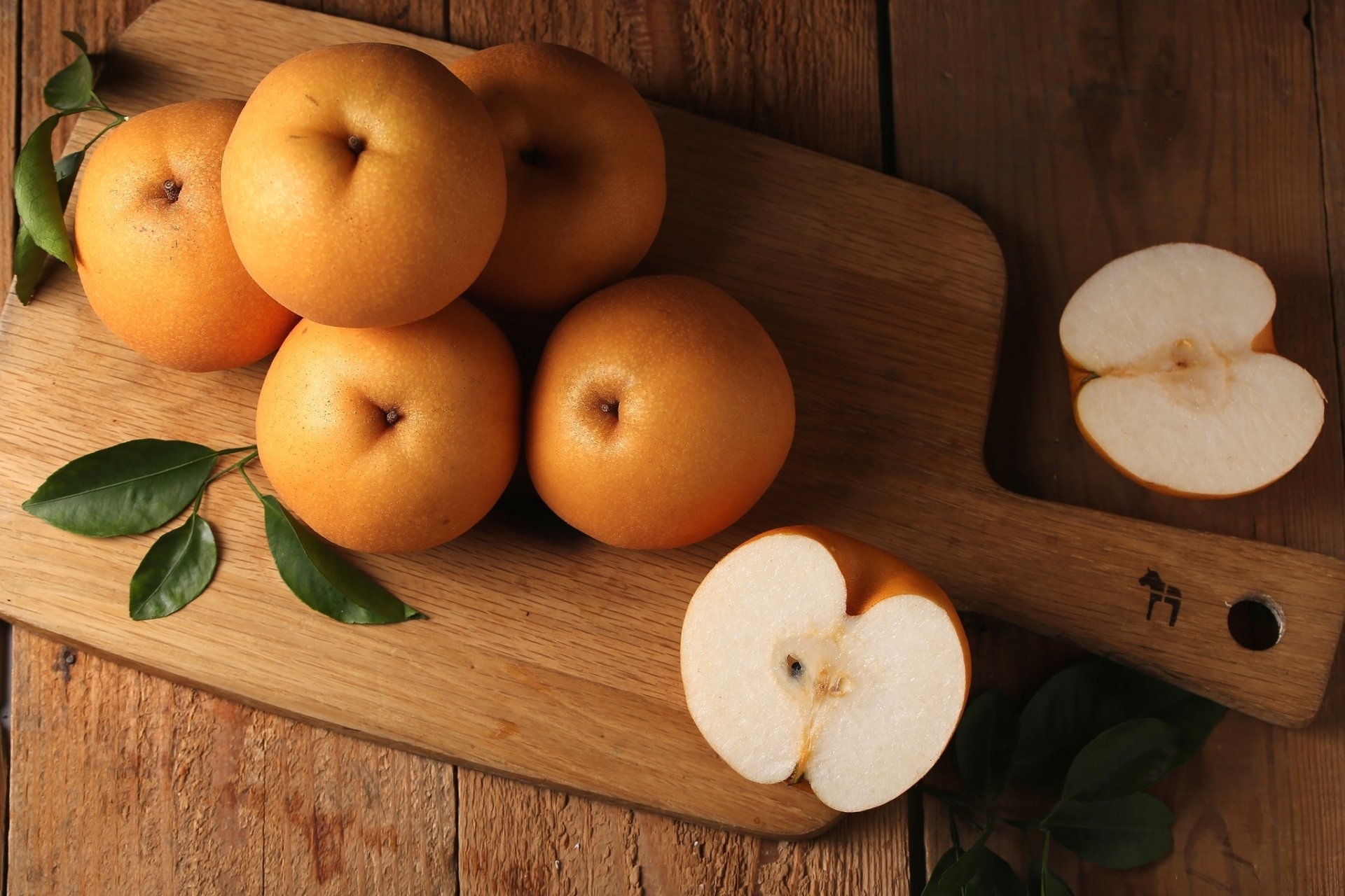 HD PC desktop wallpaper featuring fresh, whole and sliced pears arranged on a wooden cutting board, highlighting the natural texture and color of the fruit.