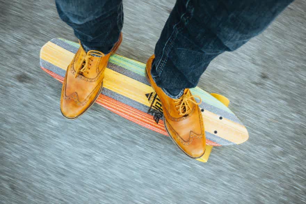 A close-up view of stylish leather shoes on a colorful skateboard, set against a dynamic background, highlighting jeans and the energy of skateboarding sports.