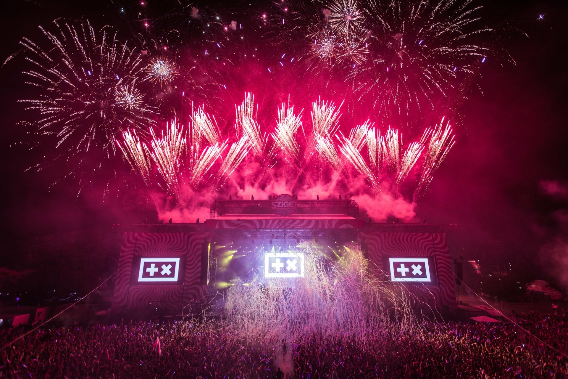 A vibrant HD desktop wallpaper and background featuring Martin Garrix performing at a music event, framed by a spectacular display of fireworks.