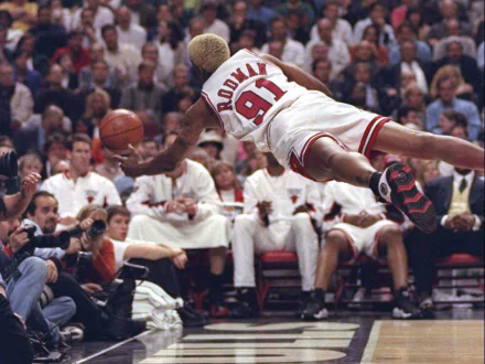 HD wallpaper of Dennis Rodman, in a Miami Heat jersey, diving for a basketball during a game.