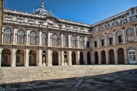 4K Ultra HD image of the Royal Palace of Madrid, Spain, showcasing the intricate man-made architecture and expansive courtyard under a clear blue sky.