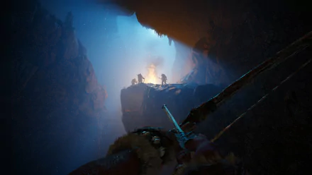 HD PC desktop wallpaper from the video game Far Cry Primal, featuring a first-person view aiming a bow toward a fiery camp inside a dark, misty cave.