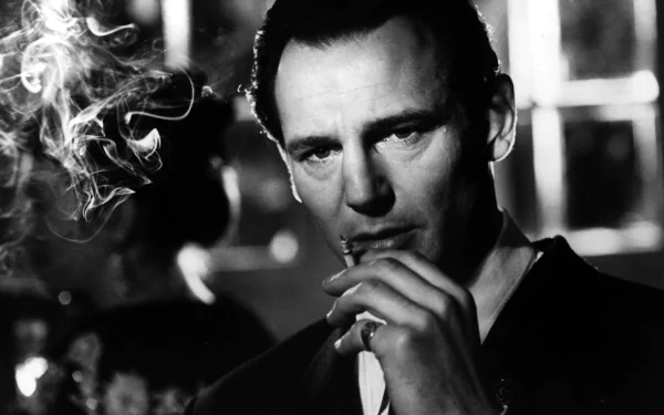 A black-and-white HD wallpaper featuring Liam Neeson smoking, capturing a powerful moment from the film Schindler's List.