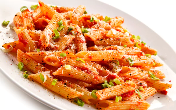 5K Ultra HD PC desktop wallpaper of a food pasta dish: saucy penne with tomato sauce, grated cheese, green onions and cracked pepper on a white plate.