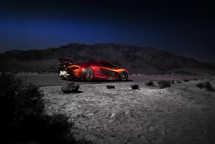 Orange McLaren P1 supercar parked on a rocky desert landscape under a deep blue night sky, captured in stunning 4K Ultra HD for a PC desktop wallpaper.