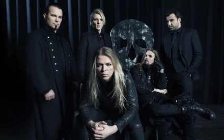 A high-definition image of the band Apocalyptica, featuring five musicians in dark attire, posed with a large skull backdrop, capturing the essence of their powerful music.