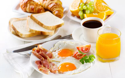 A cozy breakfast spread featuring eggs, bacon, croissants, toast, fresh fruit, coffee, and juice, set against a bright and inviting background.