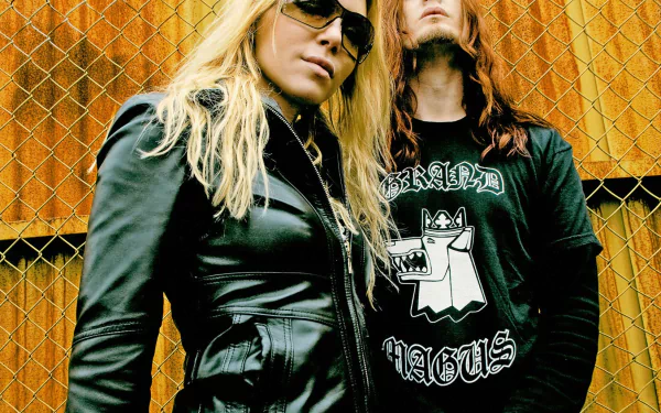 HD desktop wallpaper featuring Arch Enemy band members posing in front of a metal fence, blending music and edgy rock style.