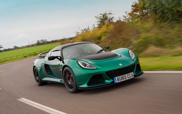 A green Lotus Exige sports car driving on a curved road with countryside scenery in the background, captured in 4K Ultra HD for desktop wallpaper use.