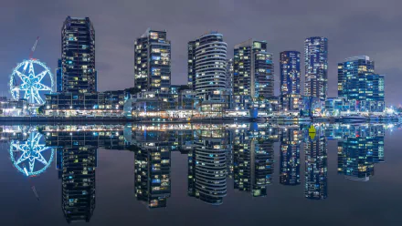 Night view of Melbourne, Victoria Harbour, Australia skyline with illuminated ferris wheel and man-made high-rise buildings mirrored in calm water — HD PC desktop wallpaper background.