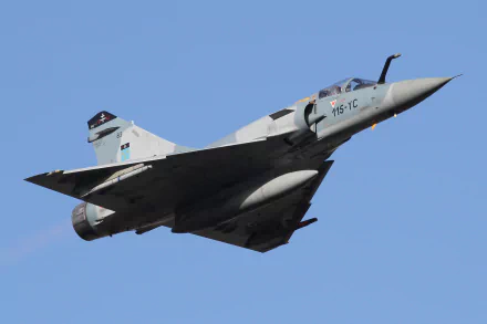 A Dassault Mirage 2000 military jet fighter soars through a clear blue sky, showcasing its aerodynamic design in this high-definition desktop wallpaper.