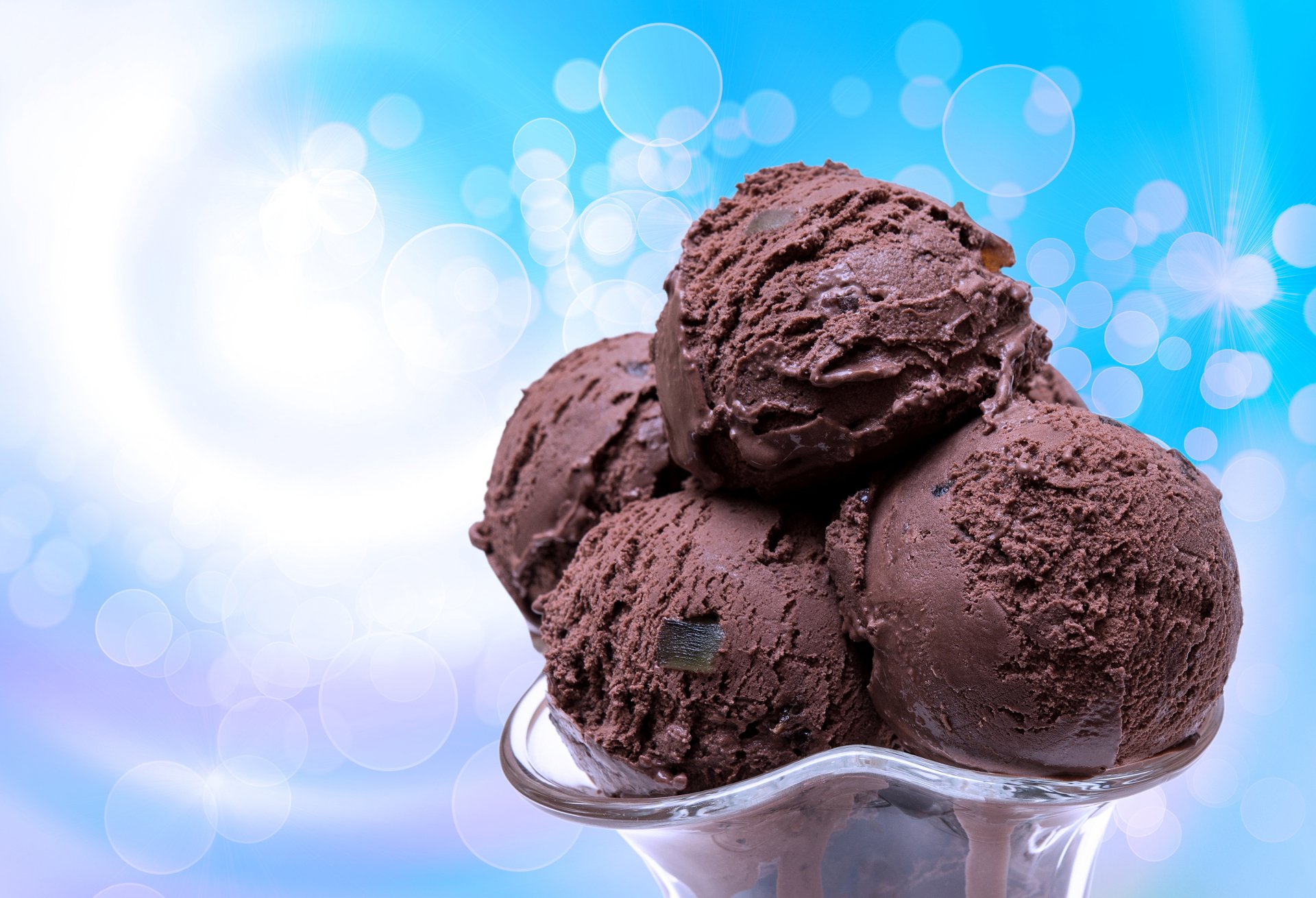 A vibrant summer scene featuring a bowl of rich chocolate ice cream, enhanced by a dreamy bokeh background, making this a delightful 4K Ultra HD desktop wallpaper.