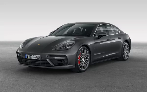 Silver Porsche Panamera sports sedan on a neutral gray floor and backdrop — 2K Quad HD PC desktop wallpaper showcasing the Porsche vehicle.