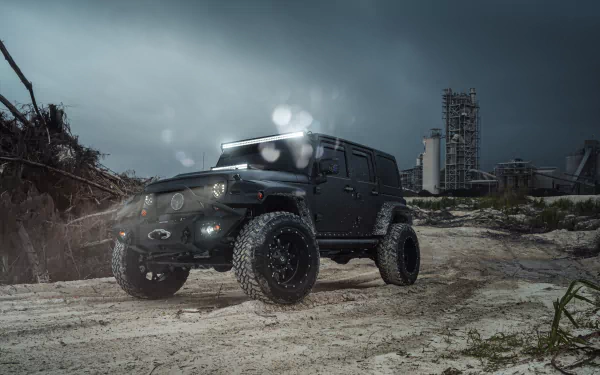 A striking black Jeep Wrangler SUV parked on a rugged terrain under a moody sky, showcasing its powerful design in this stunning 4K Ultra HD wallpaper.