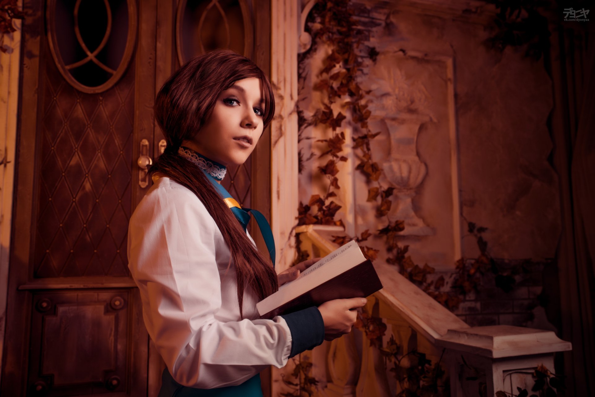 Woman cosplayer as Elizabeth (Bioshock Infinite) holding a book on an ornate, dimly lit balcony; warm cinematic tones. 5K Ultra HD PC desktop wallpaper/background.