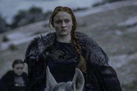 Sansa Stark, portrayed by Sophie Turner, stands resolutely on a horse in a snowy landscape, adorned in a fur cloak, showcasing a powerful moment from the TV show Game of Thrones.