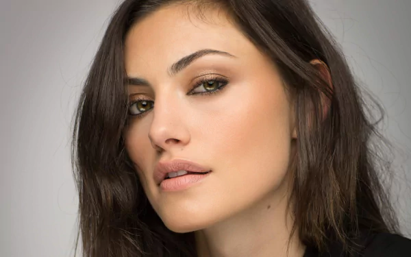 Close-up HD desktop wallpaper of a brunette Australian actress and model Phoebe Tonkin with a neutral expression against a plain background.