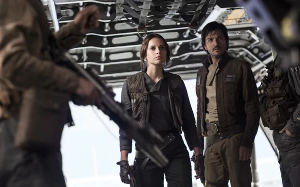 A scene from Rogue One: A Star Wars Story featuring Jyn Erso, portrayed by Felicity Jones, and Diego Luna, set against a backdrop of tense action and adventure.