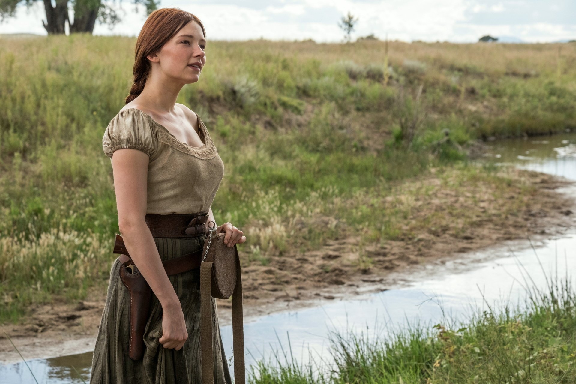 Haley Bennett stands by a serene stream in a scene from The Magnificent Seven (2016), showcasing the film's Western aesthetic in this HD desktop wallpaper.