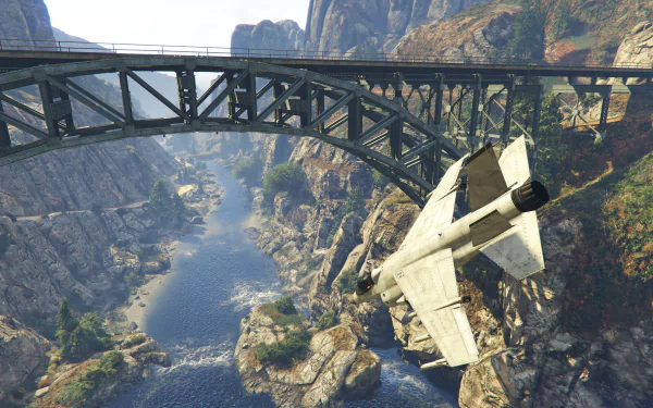 Screenshot from Grand Theft Auto V showing a jet flying under a steel bridge spanning a rocky canyon, rendered in 8K Ultra HD for PC desktop wallpaper.