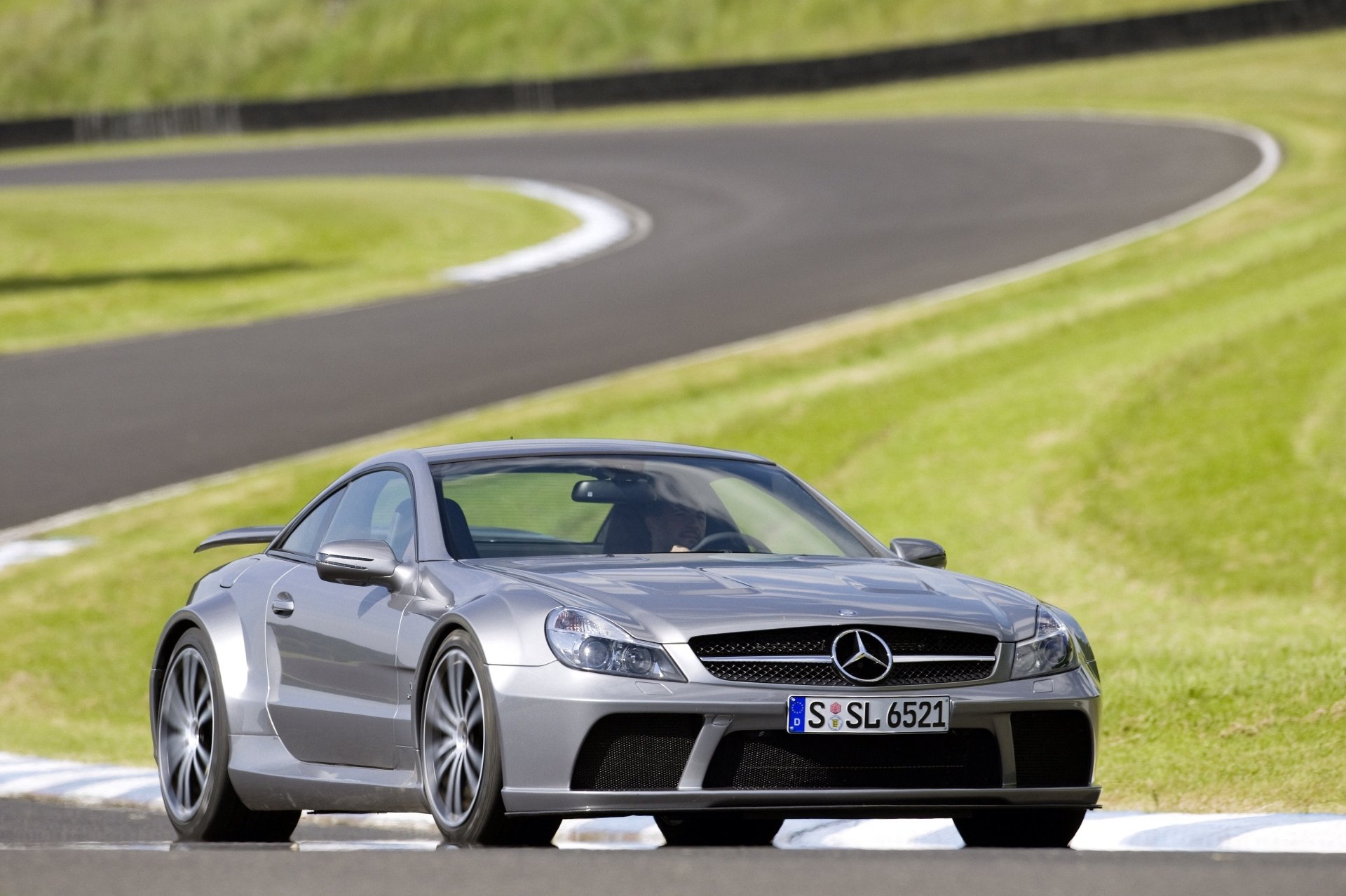 Silver Mercedes-Benz SL-Class grand tourer car driving on a curved racetrack, captured in stunning 4K Ultra HD for a PC desktop wallpaper background.