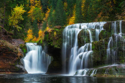 HD PC desktop wallpaper and background: lush forest nature scene with tiered waterfall cascading over mossy rocks into a calm pool, framed by autumn foliage.