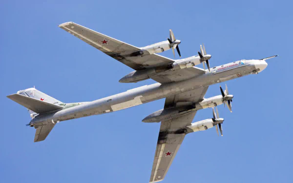 Tupolev Tu-95 bomber aircraft soaring through a clear blue sky, showcasing its military design and powerful engines. This image captures the essence of air force strength and innovation.