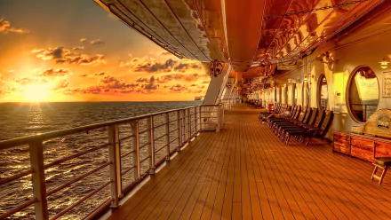 HDR sunset view from the deck of a cruise ship with vibrant clouds, empty deck chairs, and calm ocean waters, captured as an HD desktop wallpaper background.