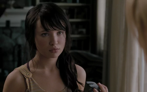 HD desktop wallpaper featuring Emily Browning from the movie The Uninvited, showing her with dark hair in a dimly lit interior setting.