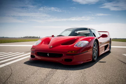 A red Ferrari F50 supercar parked on an open road under a partly cloudy sky, captured in stunning 4K Ultra HD quality.