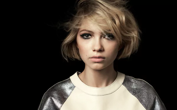 HD desktop wallpaper: close-up of an American blonde actress — young woman with short tousled hair, smoky eye makeup and a neutral expression against a dark background.