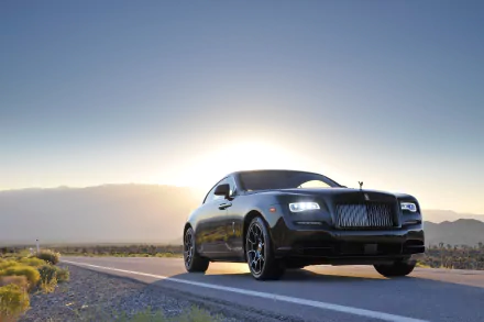 A sleek black Rolls-Royce Wraith parked on a scenic road with a sunset backdrop, captured in stunning 4K Ultra HD quality for a striking desktop wallpaper.