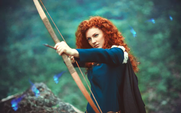 A woman in cosplay as Merida from the movie Brave draws a bow, set against a lush, mystical backdrop, showcasing her fierce determination and vibrant red hair.