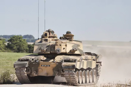 HD PC desktop wallpaper featuring a Challenger 2 military tank advancing through a dry, open terrain under a clear sky.