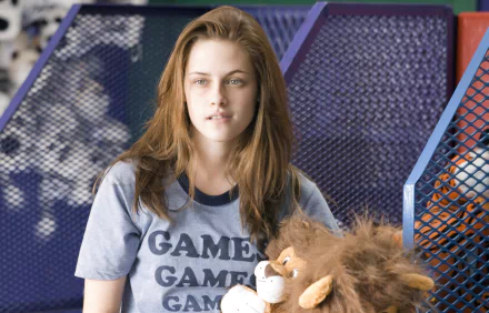 HD desktop wallpaper featuring Kristen Stewart from the movie Adventureland, with her wearing a Games t-shirt and holding a stuffed lion.