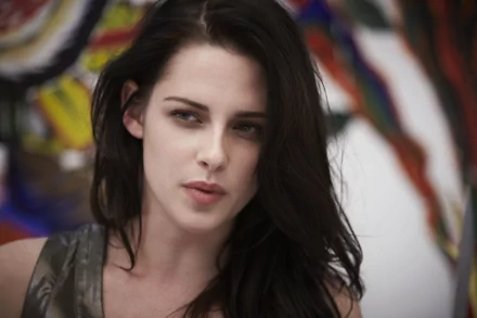 A close-up image of Kristen Stewart, showcasing her expressive gaze, set against a vibrant abstract background, designed for a 4K Ultra HD PC desktop wallpaper.