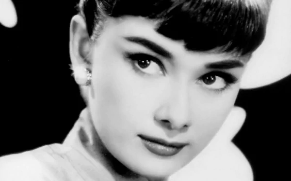 Black-and-white HD desktop wallpaper: close-up portrait of a classic female celebrity with short bangs, refined features and earrings, gazing thoughtfully off-camera.