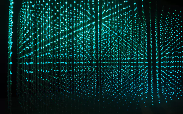 Abstract 4K Ultra HD desktop wallpaper featuring a grid of glowing turquoise dots creating a shimmering, glittering light effect in a three-dimensional space.
