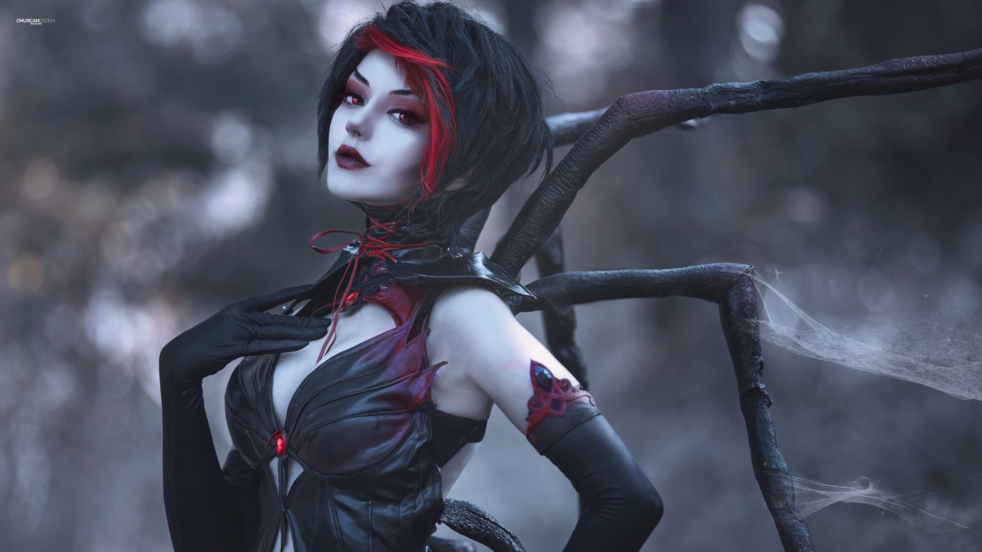 A gothic woman in striking cosplay, featuring dark attire and intricate spider-like elements, set against a moody, atmospheric background, creating a captivating HD desktop wallpaper.