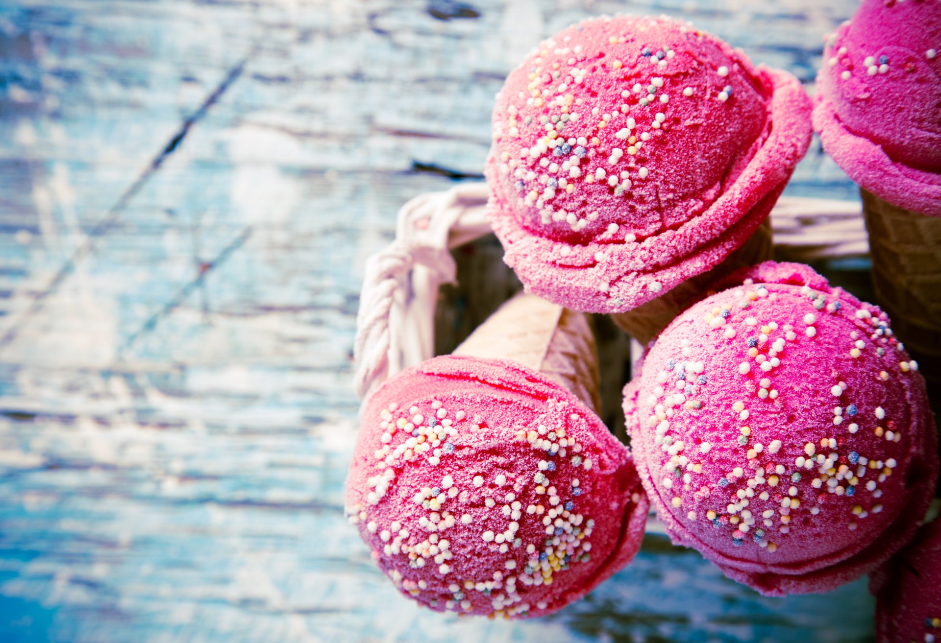 Close-up of vibrant pink ice cream scoops with colorful sprinkles in cones, captured in stunning detail for a 4K Ultra HD PC desktop wallpaper and background.
