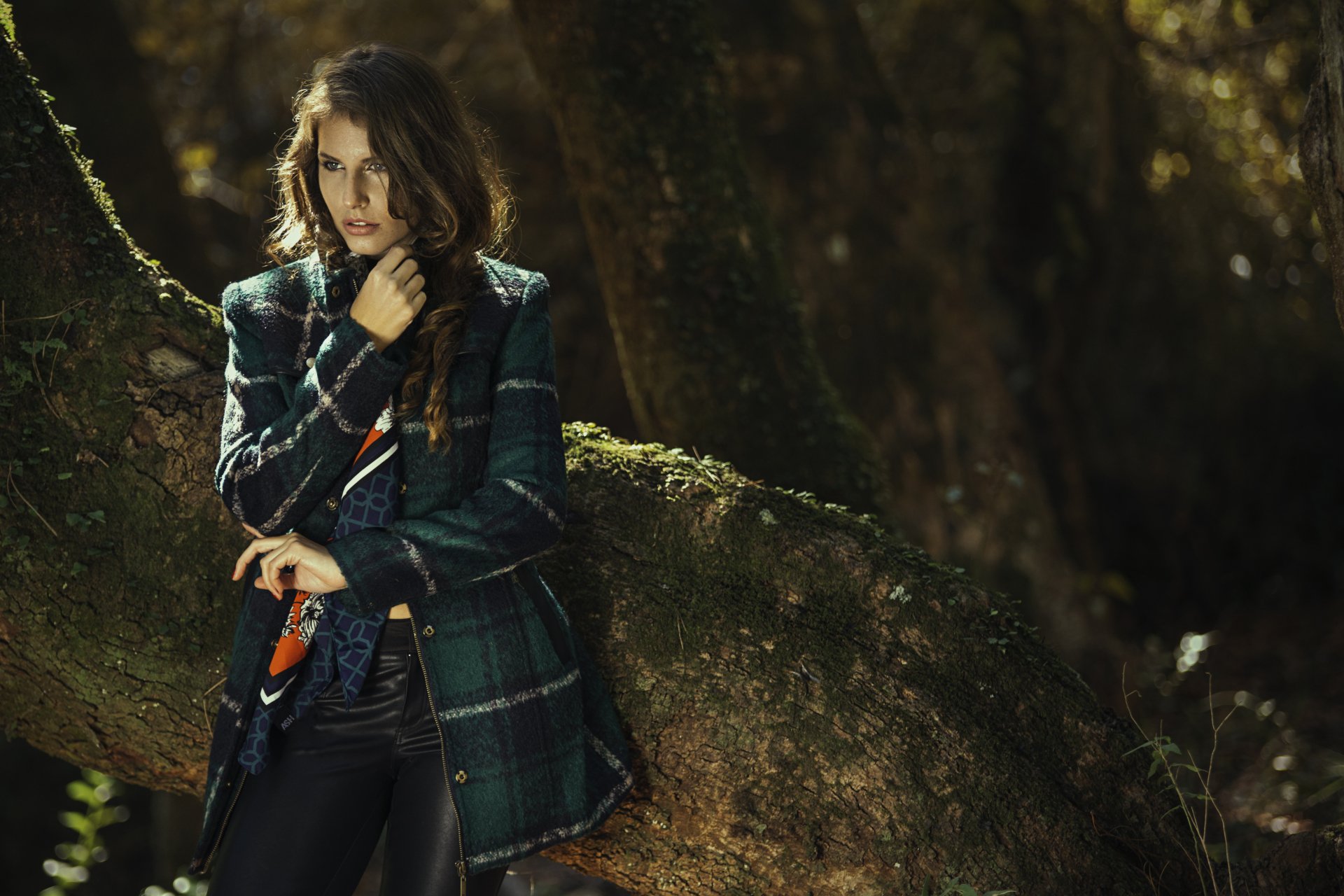 Brunette woman model stands outdoors against a moss-covered tree, captured in a detailed 4K Ultra HD PC desktop wallpaper and background.
