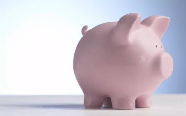 Man-made pink piggy bank on a soft gradient surface, minimalist composition — 5K Ultra HD PC desktop wallpaper/background.