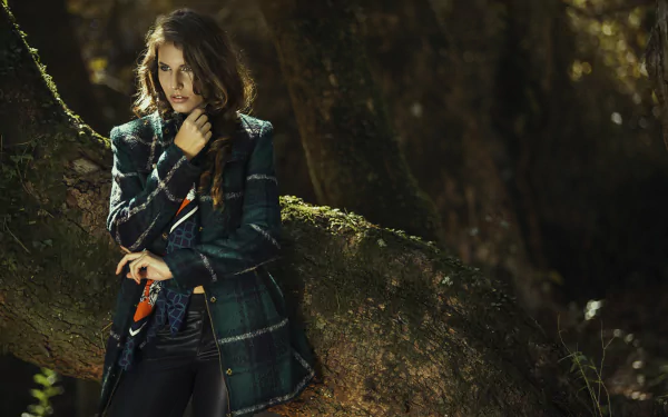Brunette woman model stands outdoors against a moss-covered tree, captured in a detailed 4K Ultra HD PC desktop wallpaper and background.